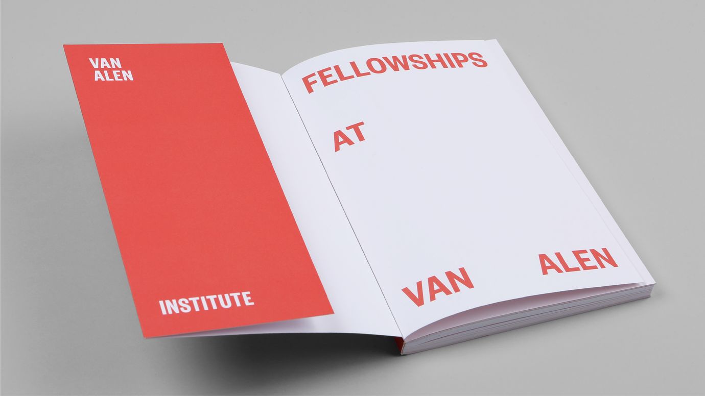 An opend book featuring a red folded flap on the left side. In the upper left corner, the name 'Van Alen' is visible, while the lower left corner displays the word 'Institute.' On the first page, the words 'Fellowship,' 'at,' 'Van,' and 'Alen' are tucked into the corners. These words share the same color as the paper of the flap on the left: a bright, cool red.
